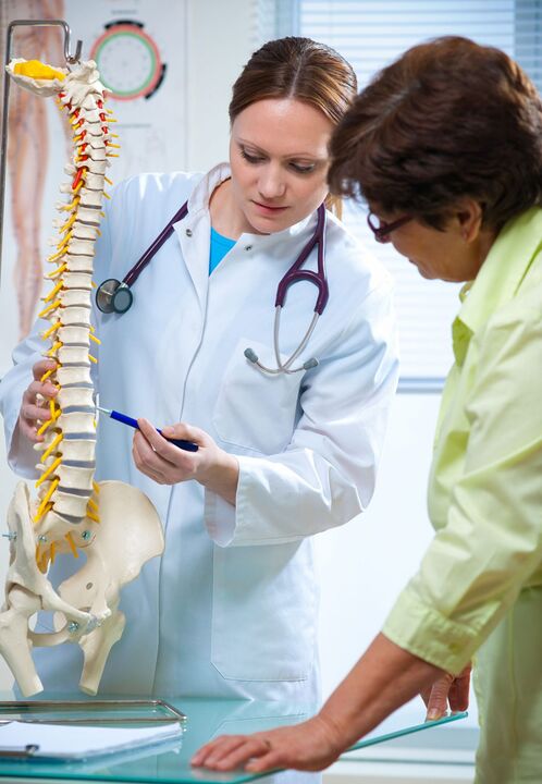 лекарят демонстрира остеохондроза на гръбначния стълб на макет